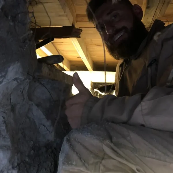 Johnathan from Sinkhole Titan in crawl space under mobile home leveling the house